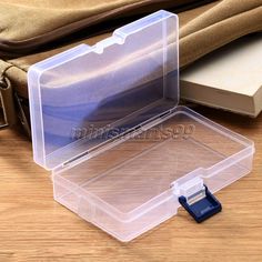 an empty plastic storage box on a wooden table with the lid open to show it's contents