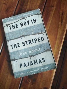 the boy in the striped pajamas by john boye pajamas is laying on a wooden floor