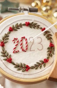 an embroidered wreath with the number twenty two in it and candy canes on top