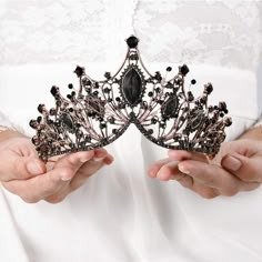 a woman holding a tiara in her hands