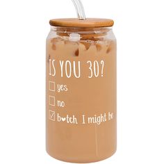 a glass jar filled with brown liquid and a metal straw sticking out of it's top