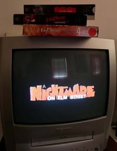 an old tv sitting on top of a wooden table next to a stack of books