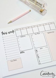 a planner and pen sitting on top of a white table next to an empty pencil