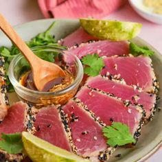 a plate topped with sliced up tuna and garnished with cilantro sauce