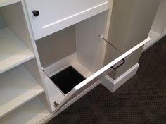 an open white cabinet on the floor in a room