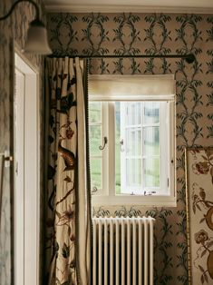 a room with a radiator, window and wallpaper on the walls in it