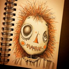 a drawing of a skeleton with orange hair on it's head is shown in front of a spiral notebook