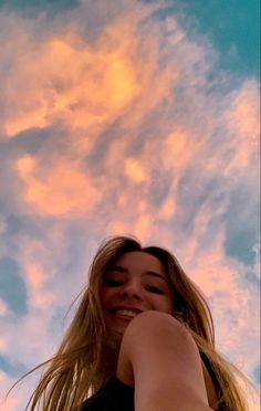 a woman is taking a selfie in front of the sky with her cell phone