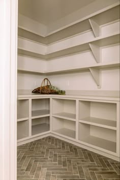 an empty white closet with shelves and baskets