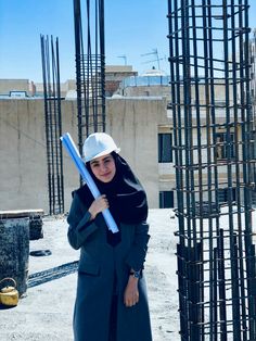 a woman holding a baseball bat on top of a construction site