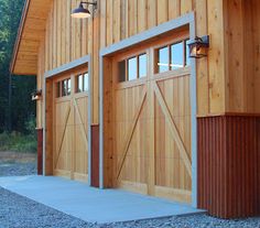 two garage doors are open on the side of a building that is made out of wood