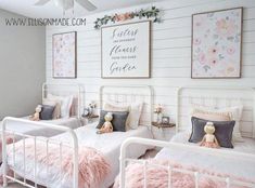 two white beds with pink fluffy pillows in a girls'bedroom