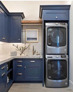 a washer and dryer in a kitchen with blue cabinets