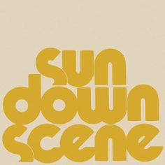 the sun down scene logo is shown in yellow and black on a beige background with white lettering