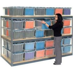 a woman standing in front of a shelf filled with plastic containers and bins on it's sides