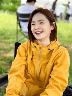 a woman sitting in a chair smiling at the camera