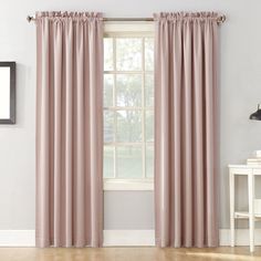 a living room with white walls and pink curtains