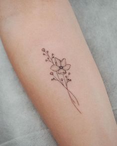 a woman's arm with a flower tattoo on the left side of her arm