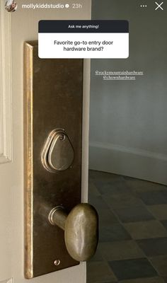 a door handle on the side of a white door with a black and gold design