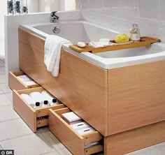 a bath tub with drawers underneath it in a bathroom