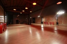 an empty dance studio with red lights and wooden floors