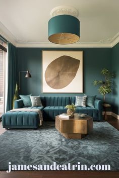 a living room with green walls and blue couches in front of a painting on the wall