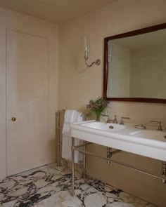 a bathroom with two sinks and a mirror