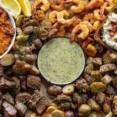 a platter filled with different types of food including shrimp, potatoes and broccoli