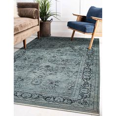 a blue rug with an ornate design on the floor in front of a couch and chair