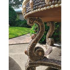 a bench made out of seashells and shells on the side of a house