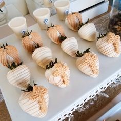 a table topped with lots of white chocolate covered strawberries