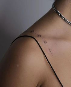 the back of a woman's shoulder with small stars on her left arm and chest