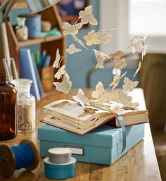 an open book sitting on top of a wooden table next to a lamp and other items