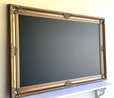 a gold framed chalk board mounted on a wall