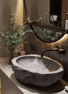 a bathroom sink sitting on top of a counter next to a vase with flowers in it