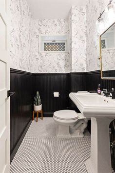 a white toilet sitting next to a sink in a bathroom under a mirror and tiled floor