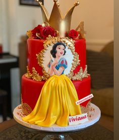 a red and yellow cake with a snow queen on top