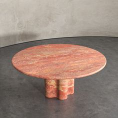 a round marble table on a black floor