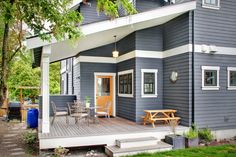 a blue house with white trim and wooden deck