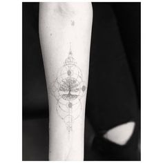 a woman's arm with a tree and geometric shapes on the left inner forearm