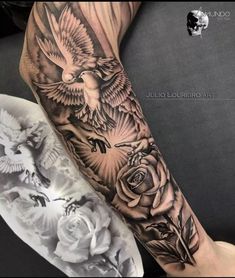 an arm with black and white tattoos on it that has roses and birds in the background