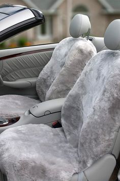 the interior of a car covered in fluffy white blankets and plush steering wheel covers,