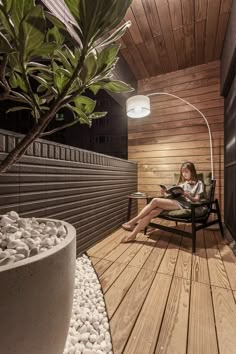 a woman sitting in a chair on top of a wooden deck