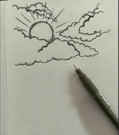 a drawing of a sun and clouds with a pen on top of the paper next to it