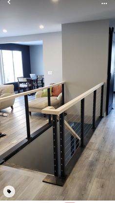 a living room filled with furniture and a wooden floor next to a wall mounted tv