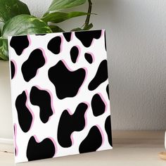 a black and white cow pattern with pink spots on it art board print by person