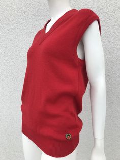 "A warm, stylish and cute waistcoat all in one. The vest is bright red, V-neck, very stretchy and well loved and maintained. A beautiful and perfect gift for yourself or your loved one. Material: 100 % wool. Size: the label does not specify the size and it is best suited for wearers EU 36/38, UK 8/10, S-Small/M - Medium. Please also check the measurements at the bottom: MEASUREMENTS: Shoulder: 16.14 inch / 41 cm Armpit to Armpit: 17.91 inches / 45.5 cm Waist: 17.32 inch / 44 cm Length: 27.36\" / 69.5 cm CONDITION: in very good vintage condition.  All measurements are taken when the garment is flat. Due to lighting, color of product may slightly vary compared to photos. Follow our store for new exclusive vintage clothing just for YOU! SHIPPING * I ship worldwide via Priority mail (Lietuvos Casual Red V-neck Vest, Red V-neck Sweater Vest For Winter, Red Cotton Casual Sweater Vest, Casual Red Cotton Sweater Vest, Casual Red Sweater Vest For Winter, Wool Sleeveless Sweater Vest, Casual Wool Sleeveless Vest, Casual Fitted Wool Sweater Vest, Casual Sleeveless Wool Vest