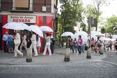 several people walking down the street with umbrellas