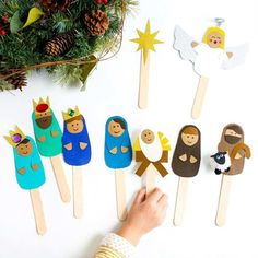 a person is making popsicles made to look like nativitys and angels on sticks