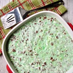 a casserole dish filled with green sauce and nuts